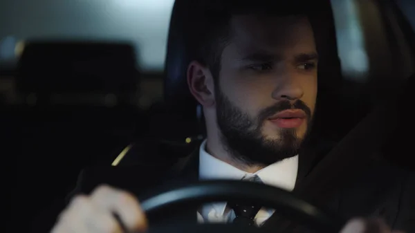 Young Businessman Looking Aside While Driving Car Night — Stockfoto