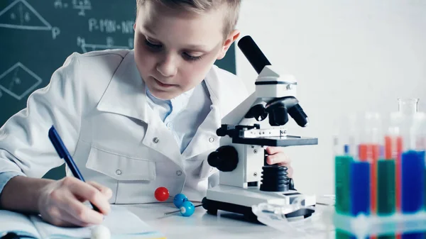 Schoolkid White Coat Making Notes Microscope Lesson Classroom — 스톡 사진