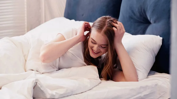 Positive Young Woman Touching Hair While Lying Bed Morning — Stok Foto