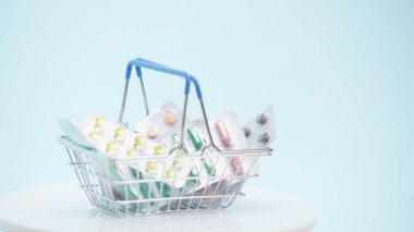small shopping basket with different medicaments on blue  clipart