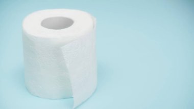 soft and white toilet paper on blue background  clipart