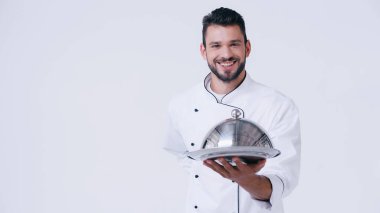 Gülümseyen şef elini arkada tutarak servis tabağını beyaza sarmış bekliyor.