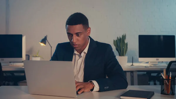 Empresário Afro Americano Usando Laptop Perto Notebook Escritório Noite — Fotografia de Stock