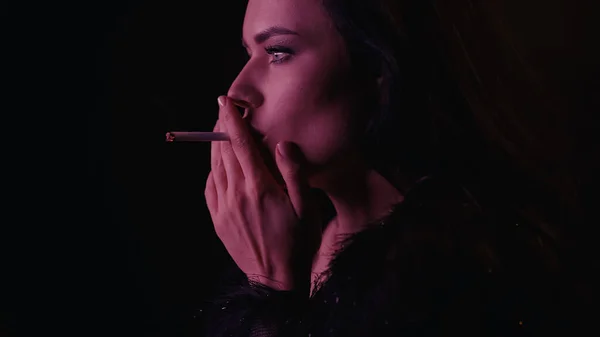 Junge Frau Raucht Zigarette Und Schaut Isoliert Auf Schwarz Mit — Stockfoto