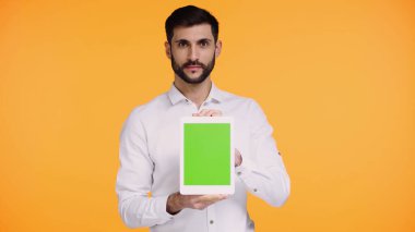 Tişörtlü sakallı adam elinde dijital tablet, yeşil ekranlı, sarı ekranlı.