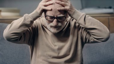 Senior man with dementia having headache and touching head clipart