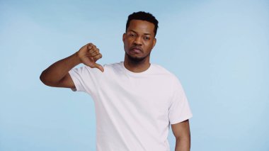 Afro-Amerikan tişörtlü bir adam mavi tişörtlü, başparmağını göstermiyor.