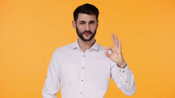 Homem Barbudo Camisa Branca Mostrando Sinal Enquanto Pisca Isolado Amarelo — Fotografia de Stock