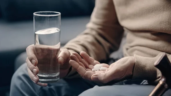 認知症の老人が錠剤やコップ一杯の水を飲み — ストック写真