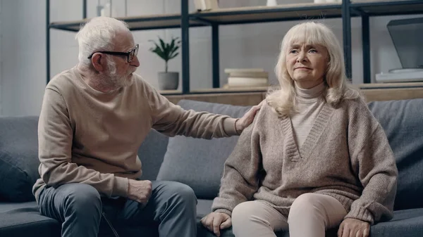 Senior man calming down confused wife with dementia