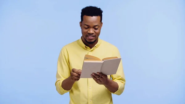 Gelukkig Afrikaans Amerikaanse Man Geel Shirt Lezen Boek Geïsoleerd Blauw — Stockfoto