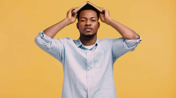 Trött Afrikansk Amerikansk Man Blå Skjorta Hålla Bok Huvudet Isolerad — Stockfoto