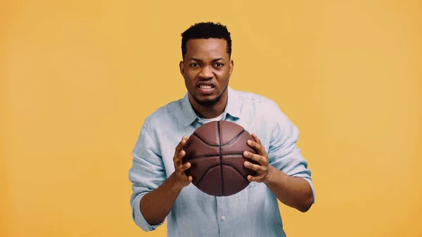 Ontevreden Afro Amerikaanse Man Houdt Basketbal Geïsoleerd Geel — Stockfoto