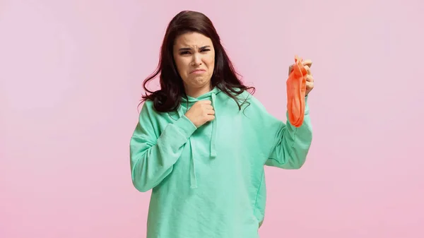 Jong Walgelijk Vrouw Turquoise Hoodie Houden Stinkende Sokken Geïsoleerd Roze — Stockfoto