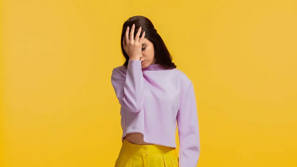 Mujer Joven Escéptica Sudadera Púrpura Pie Tocando Cabeza Aislada Amarillo — Foto de Stock