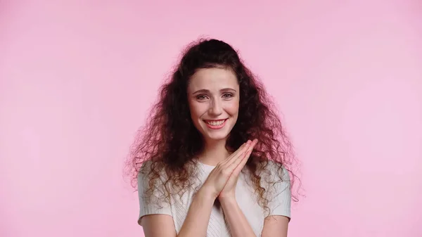 Joyeuse jeune femme aux cheveux bouclés isolé sur rose — Photo de stock