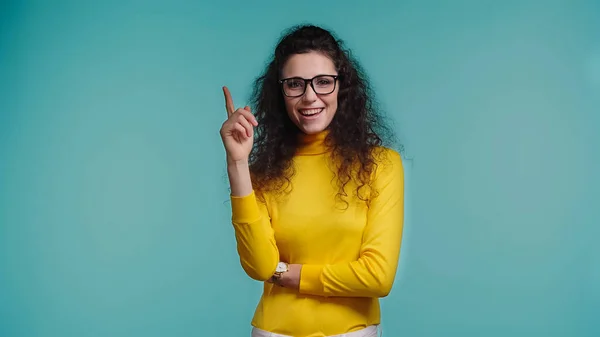 Щаслива молода жінка в окулярах має ідею ізольована на синьому — стокове фото