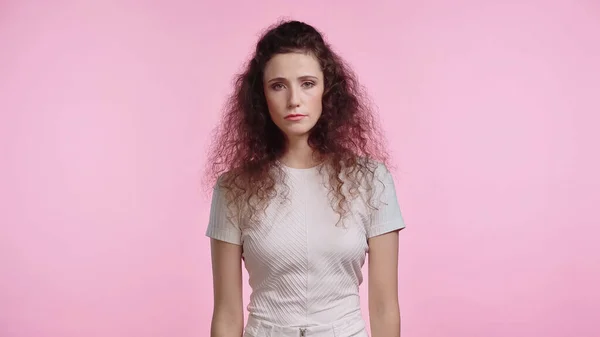 Triste giovane donna guardando la fotocamera isolata su rosa — Foto stock