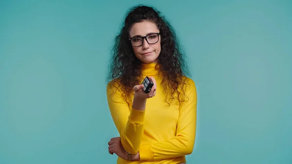 Unzufriedene Frau mit Fernbedienung, die Kanäle isoliert auf blau anklickt — Stockfoto