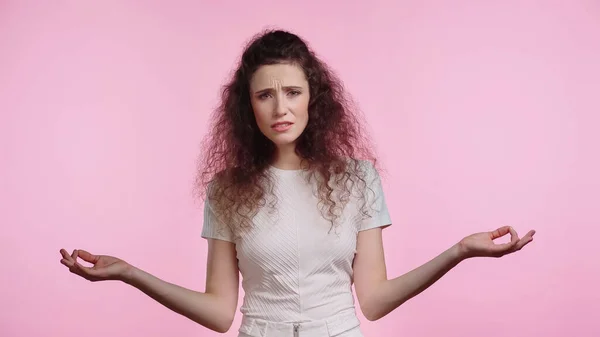 Unzufriedene Frau zeigt achselzuckende Geste auf rosa — Stockfoto