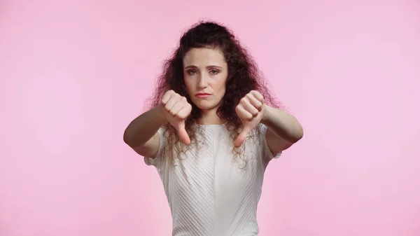 Desagradado jovem mulher mostrando polegares para baixo isolado em rosa — Fotografia de Stock