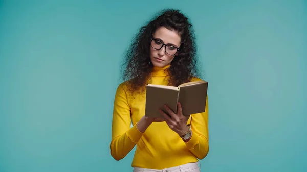 Femme concentrée dans des lunettes livre de lecture isolé sur bleu — Photo de stock