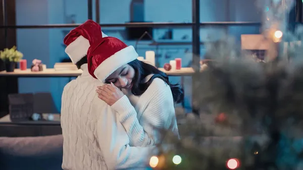 Smiling african american woman hugging boyfriend in santa hat — Stock Photo