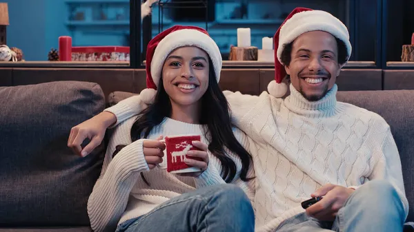 Cheerful african american couple watching movie on christmas — Stock Photo