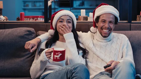 Happy african american couple watching comedy movie on christmas — Stock Photo