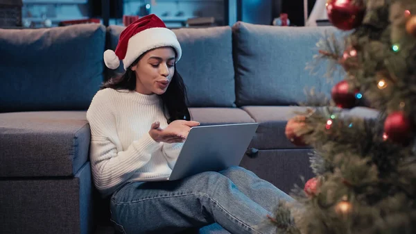 Felice donna afro-americana in cappello da Babbo Natale che invia baci d'aria mentre fa videochiamate — Foto stock