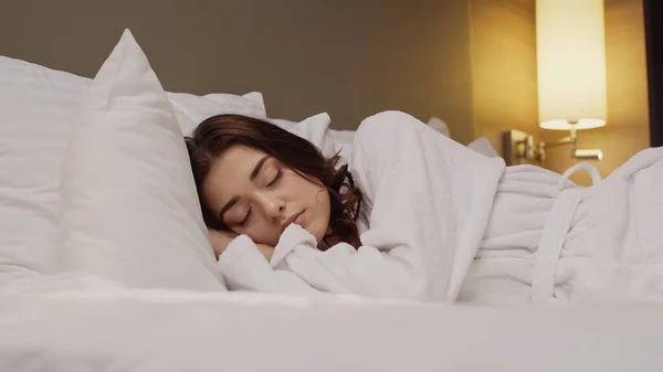 Surface level view of young woman sleeping in hotel bed — Stock Photo