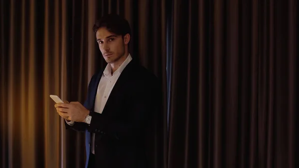 Homem de negócios conversando no smartphone no quarto de hotel — Fotografia de Stock