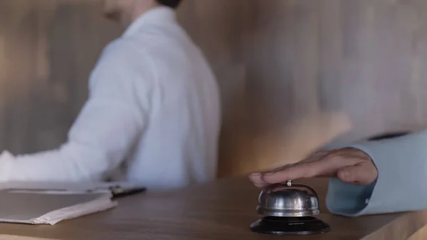 Vue recadrée du client pressant cloche de service près de la réceptionniste de l'hôtel — Photo de stock