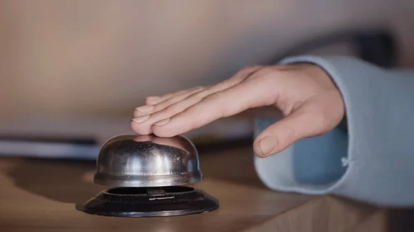 Vue recadrée de femme pressant cloche de service sur le comptoir de réception de l'hôtel — Photo de stock