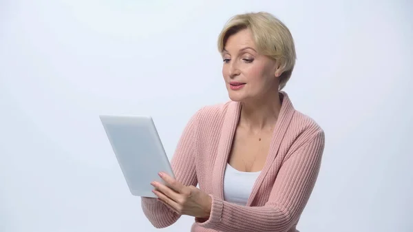 Mujer de mediana edad positiva utilizando tableta digital aislada en blanco - foto de stock