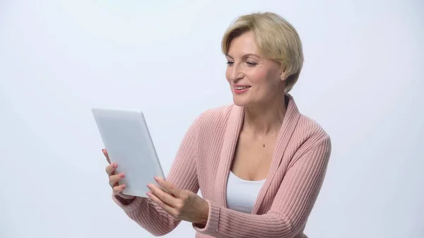 Mujer de mediana edad feliz utilizando tableta digital aislada en blanco - foto de stock