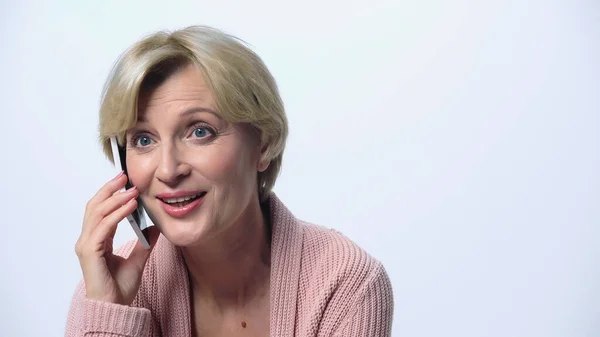 Complacida mujer de mediana edad hablando en el teléfono móvil aislado en blanco - foto de stock