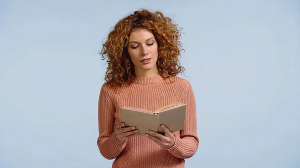 Молодая женщина с рыжими кудрявыми волосами читает роман изолирован на синий — стоковое фото