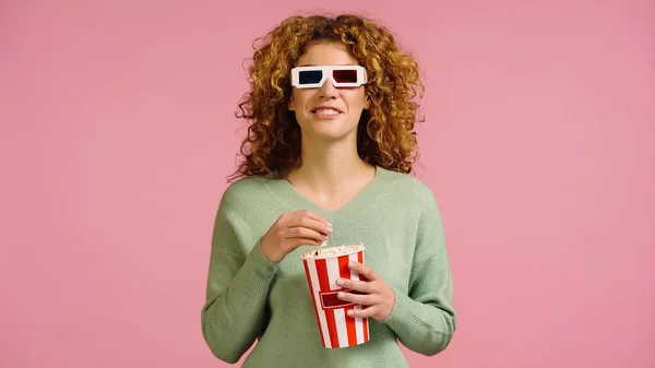 Donna allegra in occhiali 3d guardare film e mangiare popcorn isolato su rosa — Foto stock