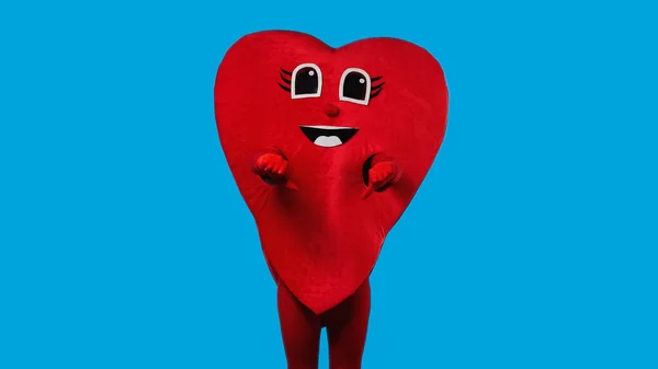 Persona in costume cuore rosso mostrando antipatia isolato su blu — Foto stock