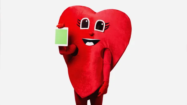 Persona in costume cuore rosso con tablet digitale con schermo verde isolato su bianco — Foto stock