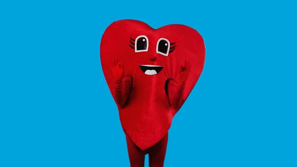 Person in happy heart costume showing okay with hands isolated on blue — Stockfoto