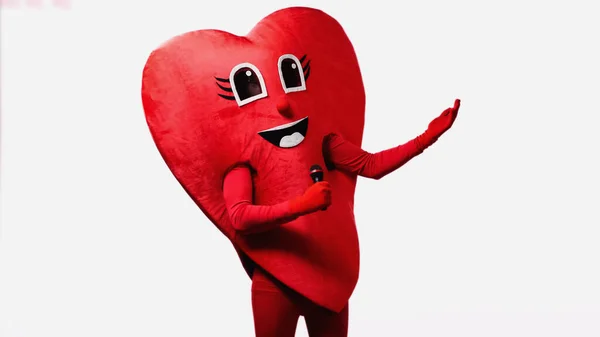 Persona in costume cuore rosso con microfono e gesti isolati su bianco — Foto stock