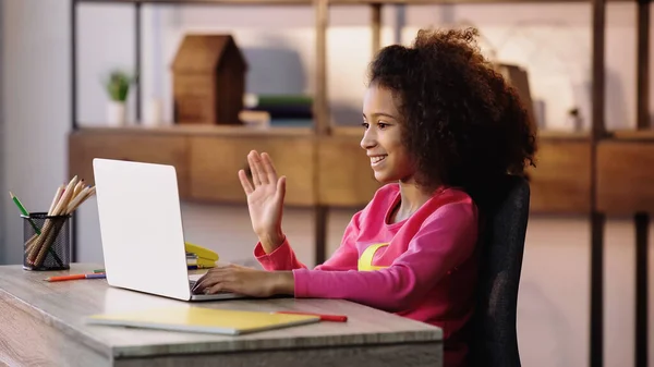 Criança americana africana feliz acenando a mão ao ter o bate-papo vídeo no laptop — Fotografia de Stock