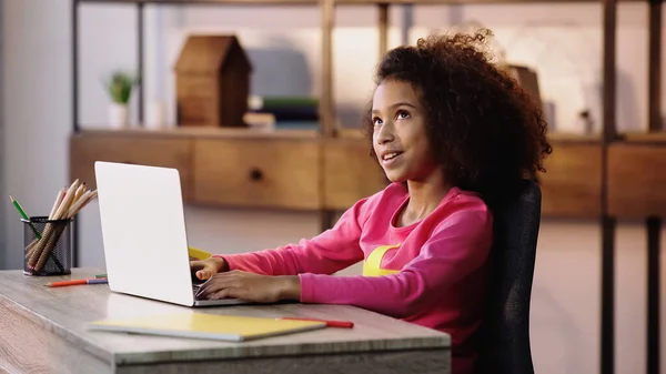 Happy african american child talking during video chat on laptop — стоковое фото