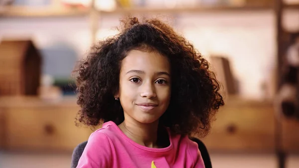 Pleased african american girl looking at camera — Stock Photo