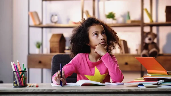 Nachdenkliches afrikanisch-amerikanisches Kind macht Hausaufgaben — Stockfoto