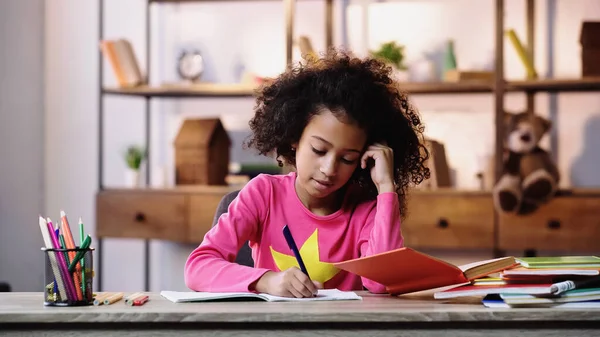 Smart african american child doing homework — стоковое фото