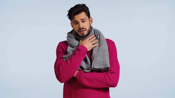 Hombre enfermo en suéter y bufanda con dolor de garganta aislado en azul - foto de stock