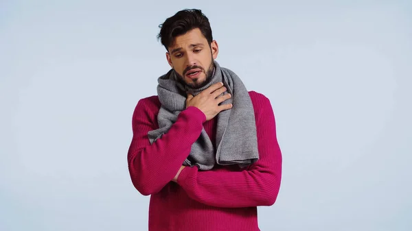Sick man in sweater and scarf having sore throat isolated on blue — Stock Photo